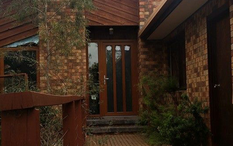 Brown brick home with glass paneled entry door