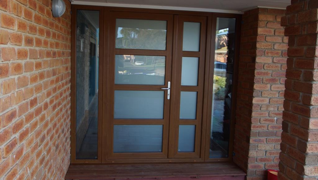 Brown brick house with glass paneled entry door