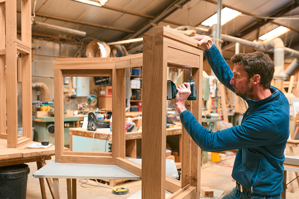 Carpenter creating a wooden window frame